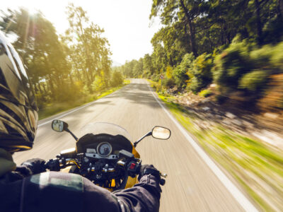 Motorcycle speeding down on an empty country road from over rider"u2019s point of view. Focus is on the motorbike with road motion blurred